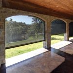 Photo of roller shades on an arched porch